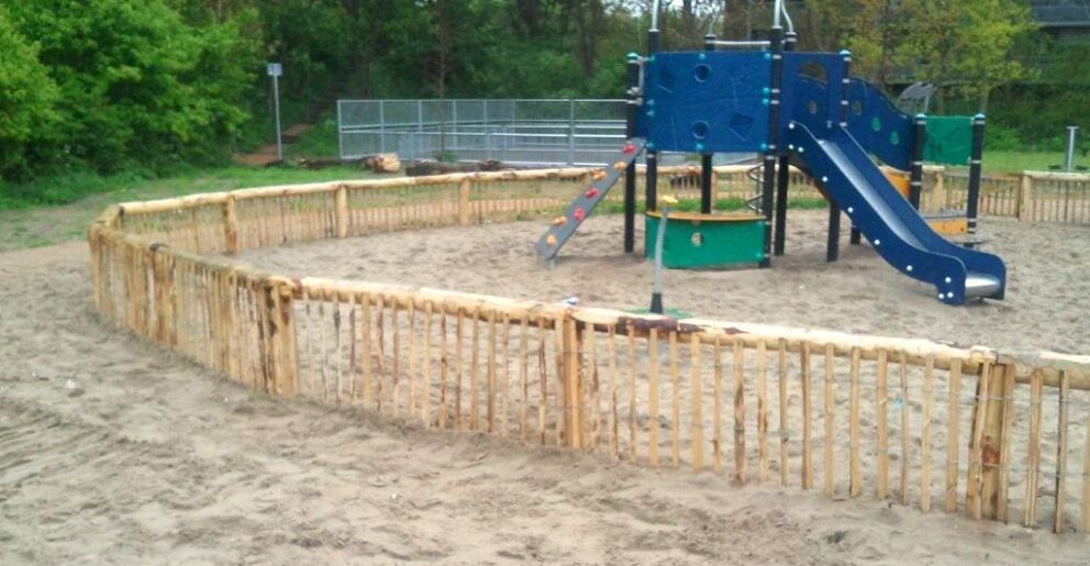 Clôture ganivielle française en bois de châtaignier de 50 cm de hauteur et avec un espacement de 6 cm. entre les lattes. Pour une aire de jeux.