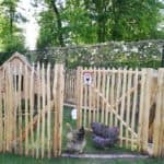 Franse rondhoutpoort van kastanjehout van 120 cm hoog bevestigd aan schappenhek dat fungeerd als een kippenren