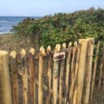Franse rondhoutpoort als doorgang naar het strand