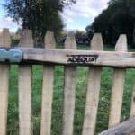 Franse rondhoutpoort van kastanjehout 120 cm hoog met het logo van Adéquat erin gebrand.