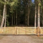 Dubbele Franse rondhoutpoort van 250 breed en 100 cm hoog bevestigd aan een omheining van schapenhek als afrastering voor een bos