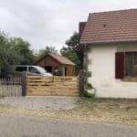 Eiken dubbele boerenlandhek op maat gemaakt. De poort staat rechts aan het huis vastgemaakt en dient als doorgang naar de parkeerplek en de achtertuin.