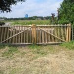 Dubbele Franse rondhoutpoort van 100 cm hoog en 200 cm breed per poortdeel bevestigd aan schapenhek van 100 cm hoog.