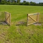 Franse dubbele rondhoutpoort van 100 cm hoog en 150 cm breed bevestigd aan schapenhek van 100 cm hoog.
