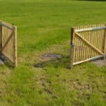 Franse dubbele rondhoutpoort van 100 cm hoog en 150 cm breed bevestigd aan schapenhek van 100 cm hoog.