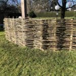 Tuin-afscheiding van wilgentenen met kastanjepalen