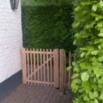 Franse rondhoutpoort van 100 cm hoog en 100 cm breed als doorgang naast een woning