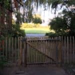 Franse rondhoutpoort van kastanjehout van 100 cm hoog bij 120 cm breed als doorgang naar een tuin