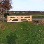 Dubbele kastenje boerenlandhek van 205 cm breed en 110 cm hoog met kastanje schaaldelen. Deze poort staat aan het begin van de wei als toegangspoort.