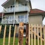 Franse rondhoutpoort van 120 cm breed bij 100 cm hoog geplaatst in een voortuin.