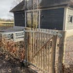 Franse rondhoutpoort van 100 cm hoog en 100 cm breed als toegang naar de tuin van de woning.