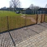 Franse rondhoutpoort van 100 cm breed en 120 cm hoog als afscheiding in de tuin tussen schapenhek geplaatst van robinia in de afmeting 120 cm met een latafstand van 4 cm