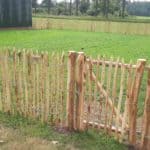 Raamwerkpoort van 80 cm breed bij 100 cm hoog als doorgang naar een wei omheind met schapenhek van 100 cm hoog met een latafstand van 4 cm