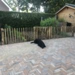 Franse rondhoutpoort van 80 cm hoog bij 80 cm breed geplaatst tussen robinia schapenhek bij een moestuin.