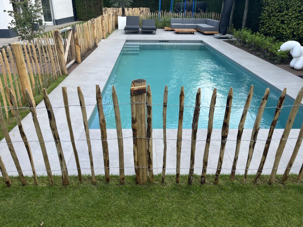 Frans kastanje schapenhek van 100 cm hoog met een latafstand van 10 cm met kastanje palen van 175 cm lang met een diameter van 10/12 cm gebruikt voor een omheining om een zwembad.