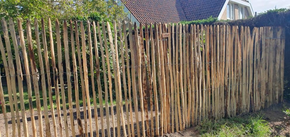 Frans schapenhek van 175 cm hoog met een latafstand van 4 cm met ongepunten kastanje palen van 250 cm lang met een diameter van 13/16 cm asl afrastering in de tuin.