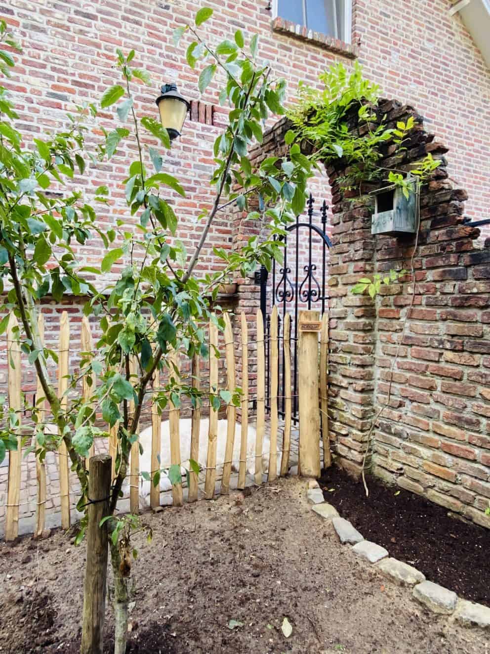 Frans schapenhek van 100 cm hoog met latafstand 6 cm en kastanje palen van 175 cm lang in diameter 10-12 cm gebruikt als omheining rondom een fruittuin en houthok,